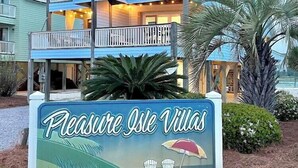 Un immeuble à plusieurs étages sur lequel on peut lire l’inscription : « Pleasure Isle Villas ».