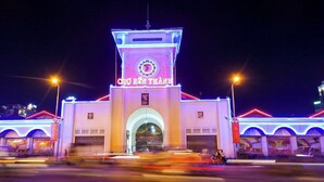 A brightly lit building with a clock tower and the sign "CHO BEN THANH" at the entrance.