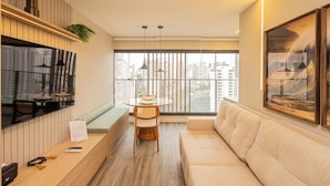 A modern living room with a sofa, a dining table, and a TV. - SSP - Soma Perdizes (São Paulo)