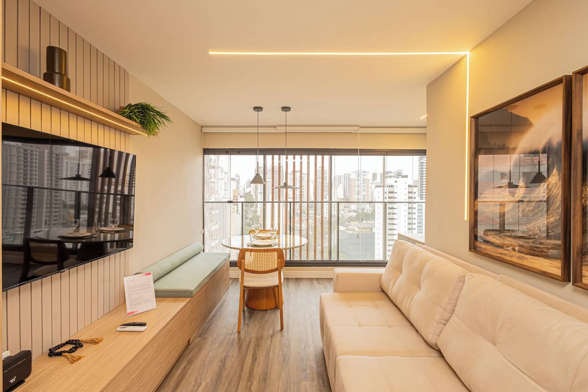 A modern living room with a sofa, a dining table, and a TV.