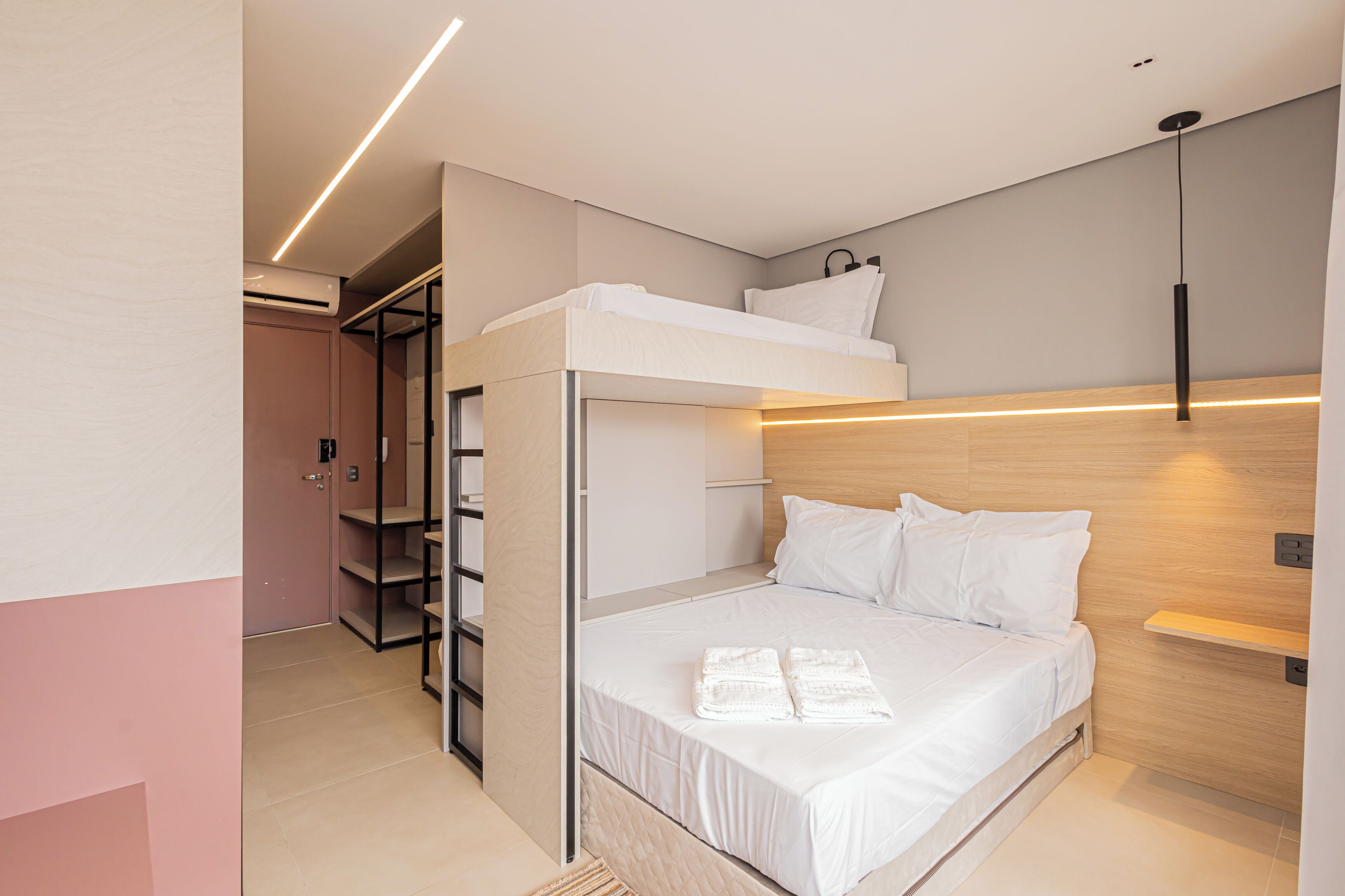 Una camera da letto moderna con una cuccetta, scaffali a muro e un comodino.