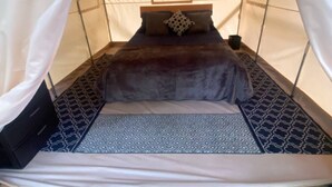 A tent with a bed, a pillow, and a headboard.