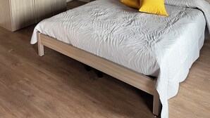 A bedroom with a bed, wooden headboard, and a wall with a leaf pattern. - Casa Vacanze Conca D'Oro (San Giorgio di Valpolicella)