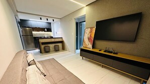 Ein modernes Wohnzimmer mit einem wandmontierten Flachbildfernseher, einer Couch und einem Couchtisch.