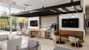 A modern interior with a seating area, a kitchen, and a large window. - The Groovy Blue Skyview (Birmingham)