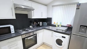 A compact kitchen with a microwave, stove, oven, washing machine, and refrigerator. - Fishermans View Summa (Fleetwood)