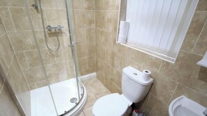 A bathroom with a glass-enclosed shower, a toilet, and a bidet.