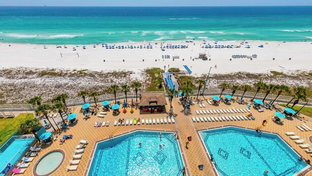 A resort with multiple swimming pools, beach access, and a view of the ocean.