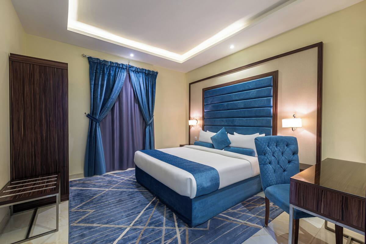 Une chambre d’hôtel moderne, dotée d’un grand lit, d’un bureau et d’une chaise.