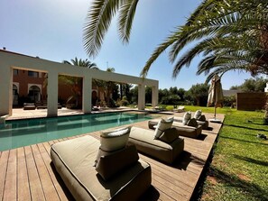 A poolside area with lounge chairs and a wooden deck. - The Garden of Siredrah, an Oasis with Pool and Hammam (Marrakech)