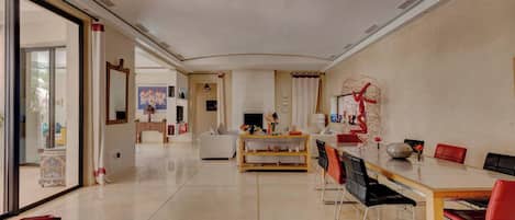 A spacious living area with a dining table, chairs, and a fireplace.