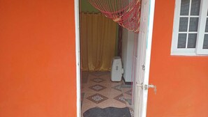 A doorway leading to a room with a patterned floor, a heater, and a yellow curtain. - welcome to a private self contained  unit  with WIFI , A.C  , private entrance  (Kingston)