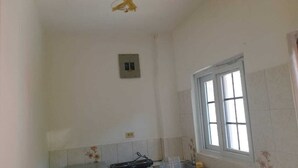 A kitchen with a window, a microwave, and a power outlet on the wall. - welcome to a private self contained  unit  with WIFI , A.C  , private entrance  (Kingston)