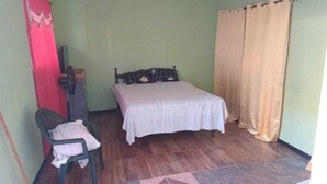 A small, simple room with a bed, a chair, and a desk. - welcome to a private self contained  unit  with WIFI , A.C  , private entrance  (Kingston)