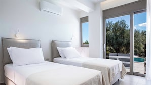 A modern hotel room with two beds, a large sliding glass door leading to a balcony with a pool view, and an air conditioning unit on the wall. - Villa Averto Anna - Two Bedroom Villa, Sleeps 4 (Rachi)
