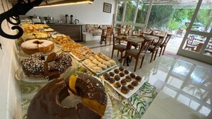 A buffet with various pastries and a chocolate cake. - CHALÉS PRINCESA ISABEL (Petrópolis)