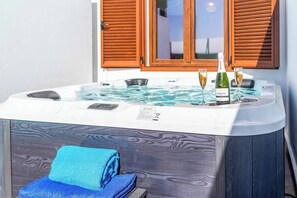 Ein Whirlpool mit zwei Weingläsern, einer Weinflasche und einem Handtuch.