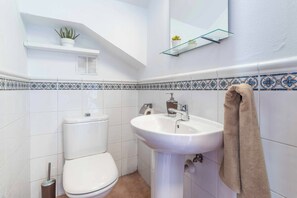 A bathroom with a toilet, sink, and towel rack.
