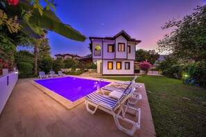 A two-story house with a swimming pool and lounge chairs. - Villa Beste - Four Bedroom Villa, Sleeps 7 (Dalyan)