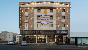 Ein Hotel mit einem Schild, das „The Palace Suites Hotel“ anzeigt, und einem Empfangsbereich.