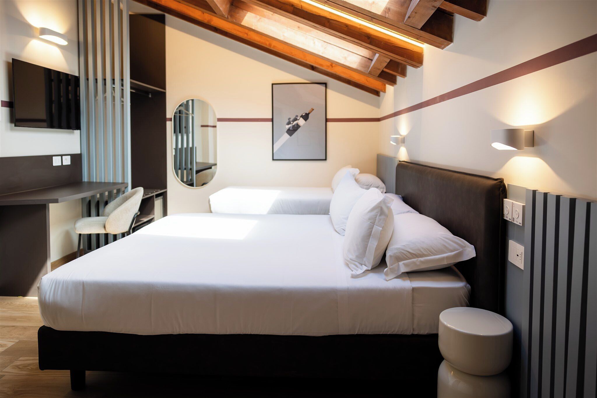 A bedroom with a bed, bedside table, chair, and a mirror.