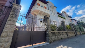 A gated entrance to a residential property with a stone wall and metal gate. - RossoVino Milano Boutique (Milan)