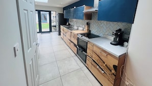 A modern kitchen with a skylight, wooden cabinets, a built-in oven, and a coffee maker. - Westmeads wings. 5 minutes walk to the harbour and close to town and beach (Whitstable)
