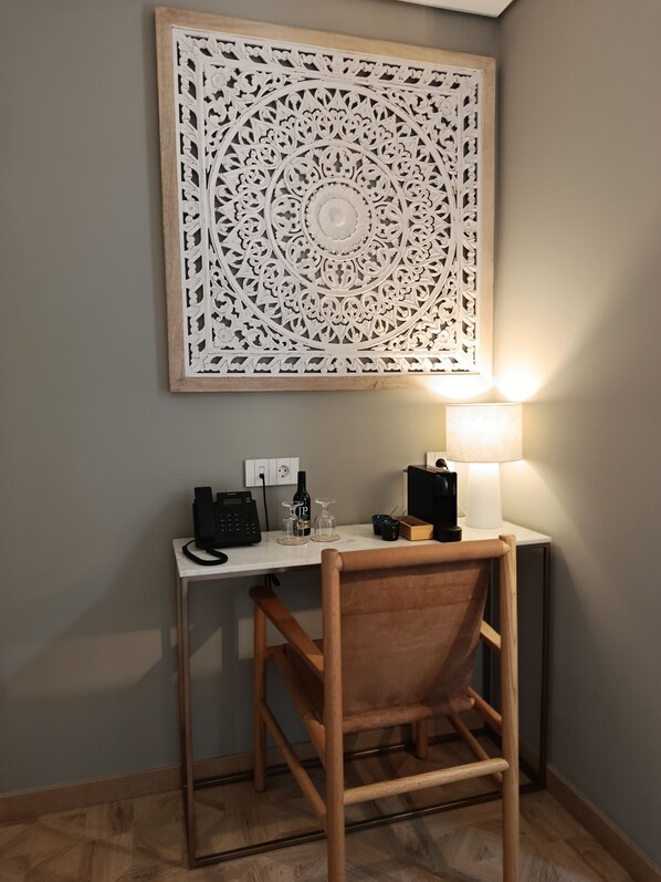Un escritorio con una computadora, una lámpara y un panel decorativo.