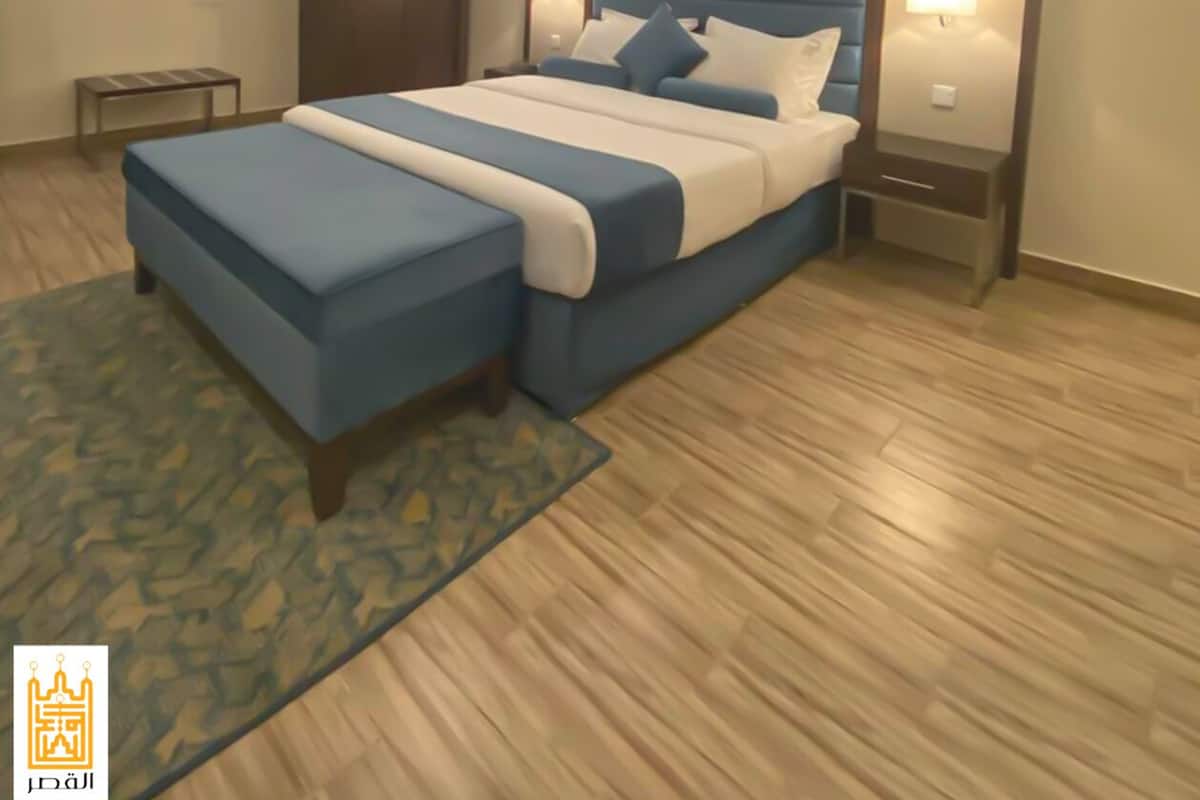A modern bedroom with a large bed, a wardrobe, a bedside table, and a nightstand.