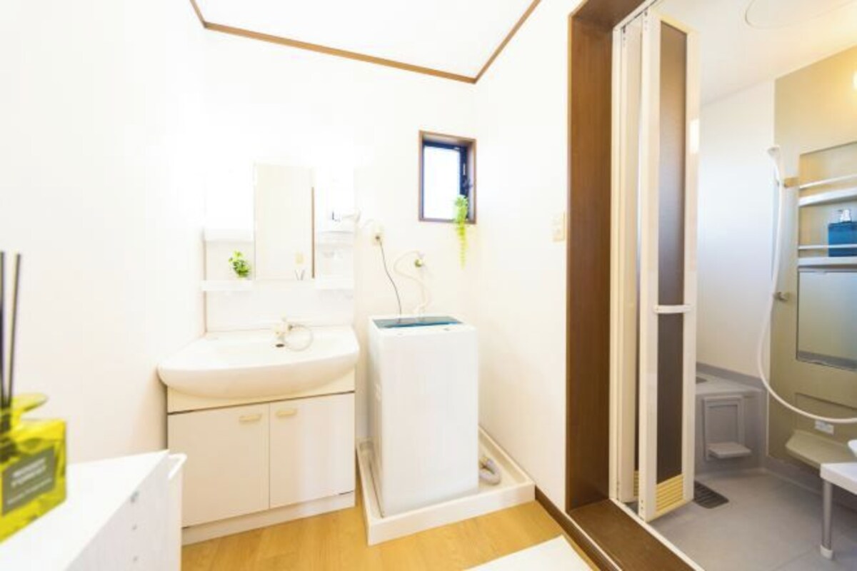A modern bathroom with a white sink, mirror, and a white toilet.