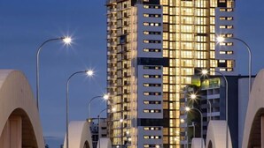 A modern hotel building with multiple floors, illuminated windows, and a prominent sign. - Lovely 2 Beds Apt with City View at South Brisbane (South Brisbane)