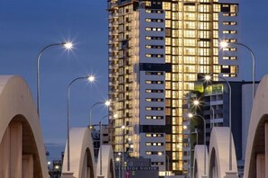 A modern hotel building with multiple floors, illuminated windows, and a prominent sign. - Lovely 2 Beds Apt with City View at South Brisbane (South Brisbane)