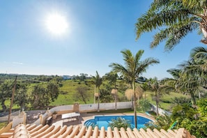 A pool area with lounge chairs and a view of a green landscape. - Villa Caty Catarina (Albufeira)
