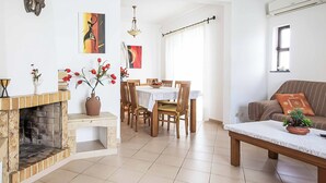 Una sala de estar con chimenea, comedor y sofá.