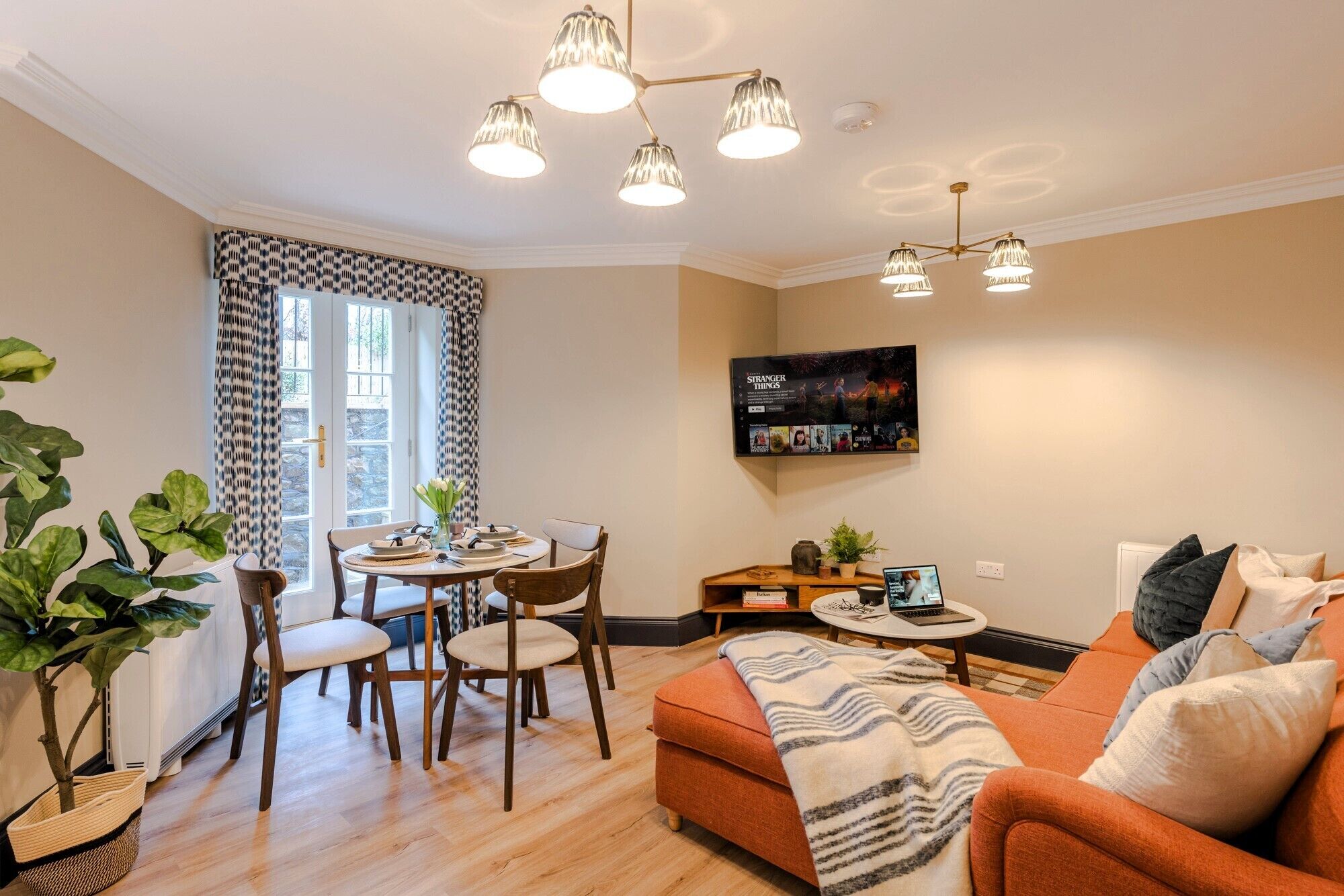Una sala de estar moderna con comedor, sofá, televisor y chimenea.