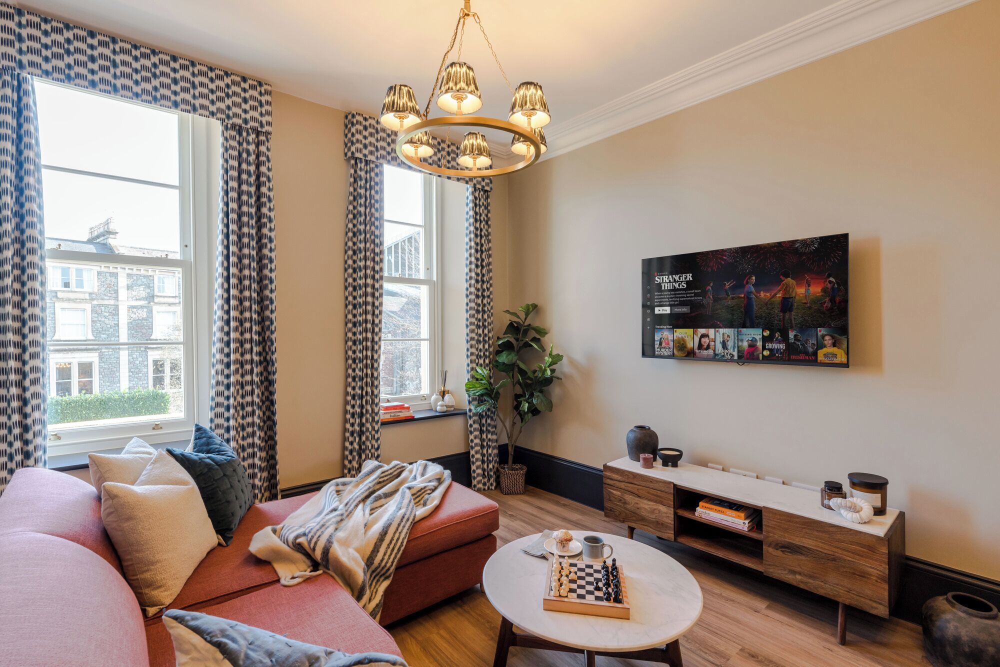 Ein Wohnzimmer mit einer Couch, einem Couchtisch, einem Fernseher und einem Bücherregal.