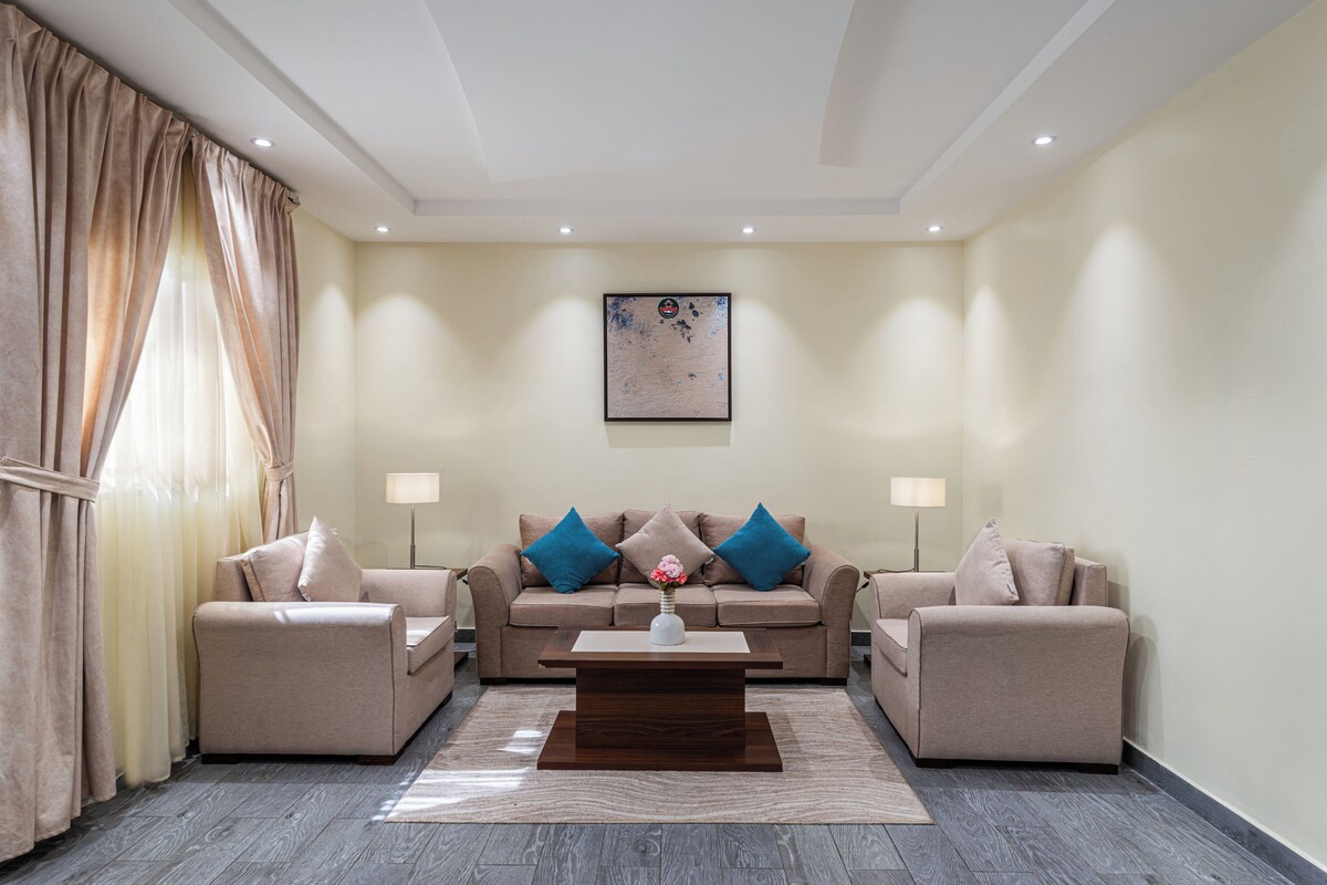 A living room with a sofa set, a coffee table, and a painting on the wall.