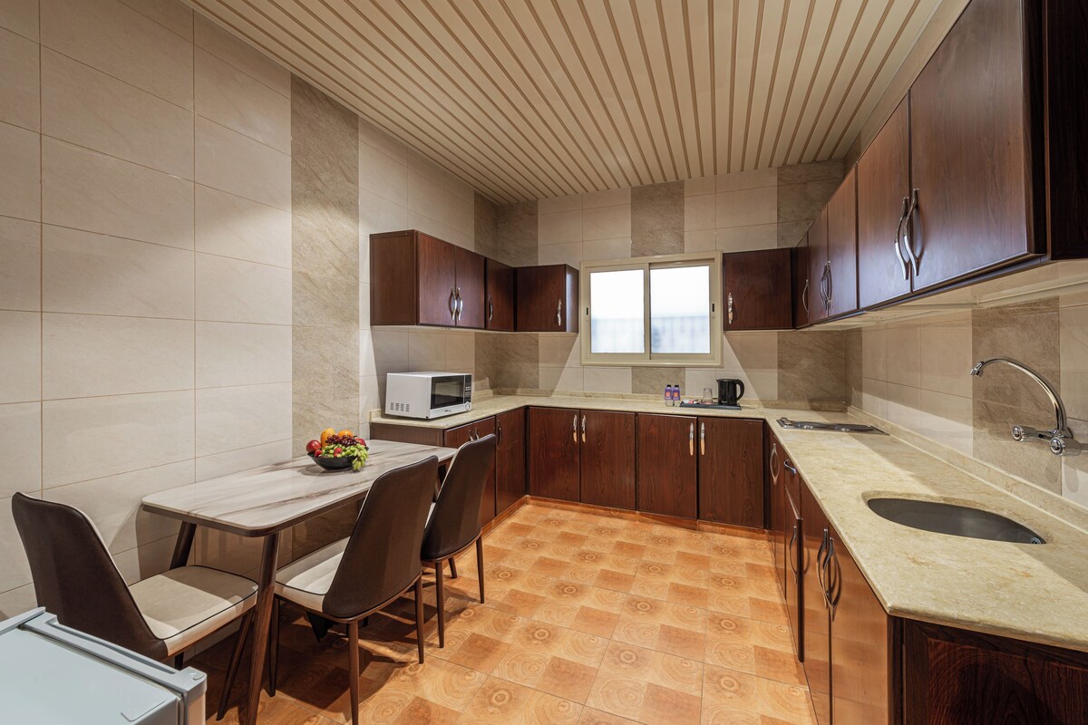 Cozinha moderna com área de refeições, incluindo micro-ondas, pia e janela.