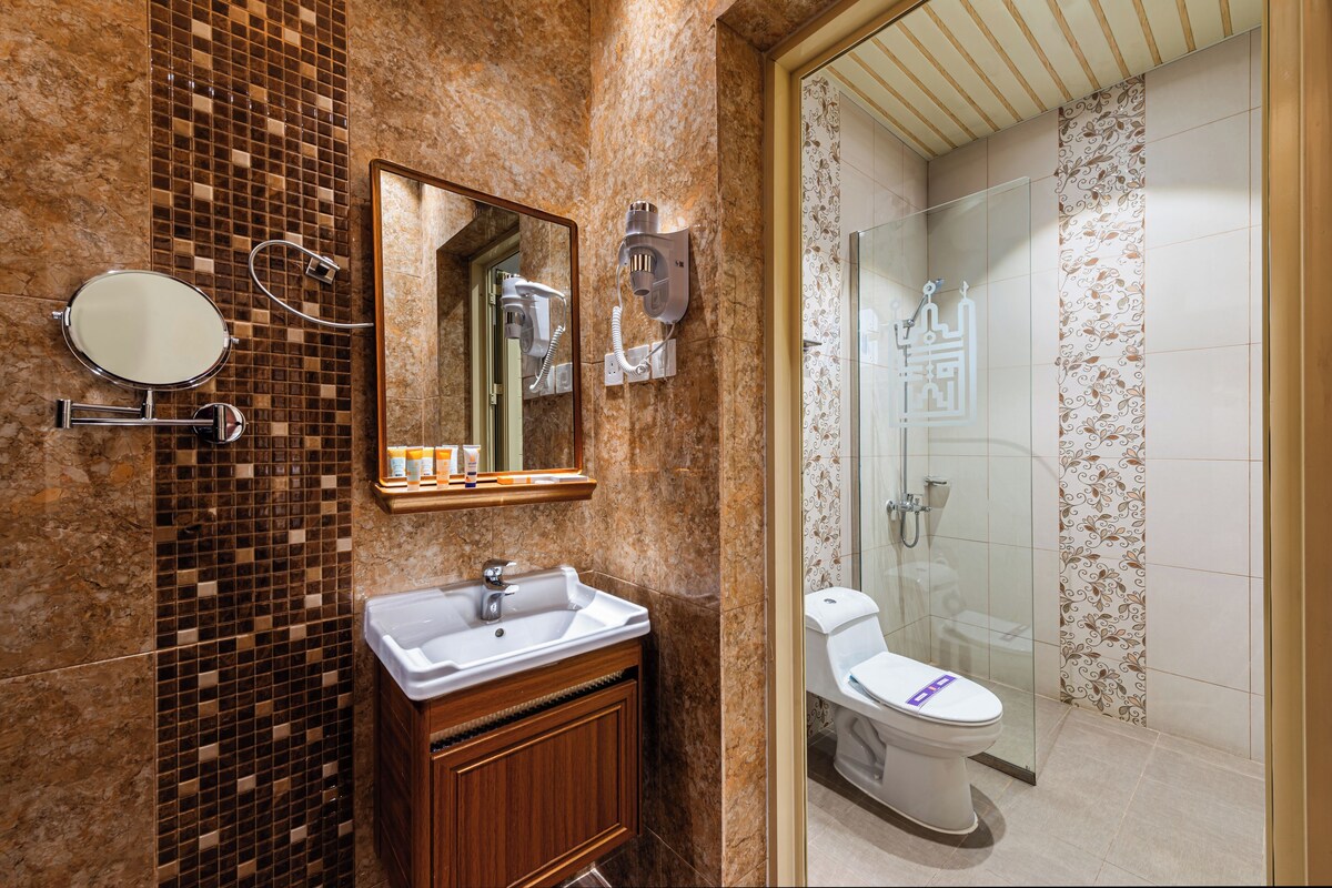 A bathroom with a sink, mirror, and a shower area.