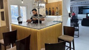 Cuina moderna amb illa central, zona de bar i seients.