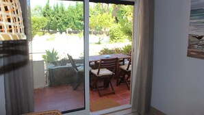 Ein Zimmer mit einer Schiebetür zum Außenbereich, mit einem Tisch und Stühlen.