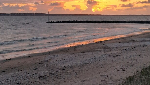 A beach with a rocky breakwater and a sunset over the water. - Mobil home 4 places terrasse couverte à 2 pas de la plage. Animaux non acceptés (Marennes-Hiers-Brouage)
