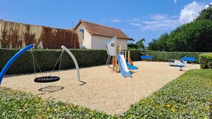 A playground with a swing set, slide, and climbing structure. - Mobil home 4 places terrasse couverte à 2 pas de la plage. Animaux non acceptés (Marennes-Hiers-Brouage)