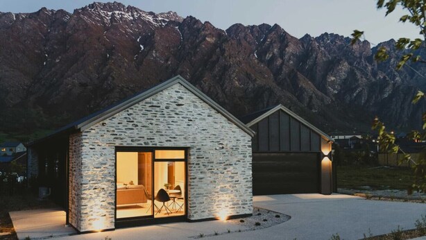A modern house with a stone facade, a large glass door entrance, and a garage. - Close to the remarkable ski field, modern and warm. (Queenstown)