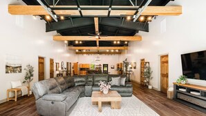 A modern living room with a sectional sofa, a wooden coffee table, and a flat-screen TV. - 5 King Beds | Sleeps 18 | Pickleball | Brew Trail (Nelson County)