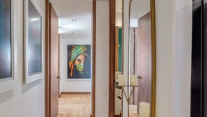 A hallway with wooden flooring, a painting on the wall, and a mirror with candles. - Elegant/Modern Apt in Poblado - Morph 1201 (Medellín)