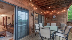 Une terrasse en bois avec une table et des chaises, une horloge et un panneau indiquant « Whisper Lake ».