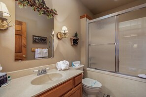 Enjoy a refreshing shower in the bathroom, featuring a shower, double sink vanity, and ample storage.