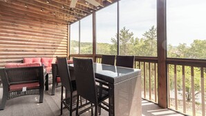 A covered outdoor area with wicker furniture, a glass table, and a ceiling fan. - 1BR Village At Indian Point 902 near SDC-Free Tickets Daily up to $500 Value (Branson)