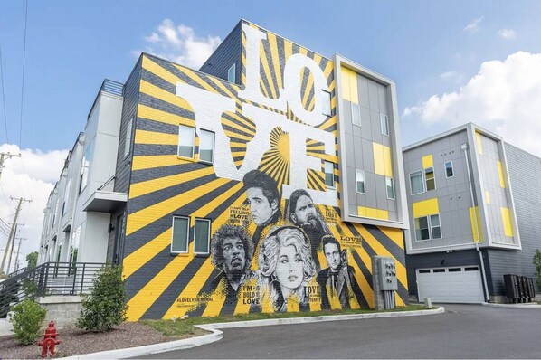 A modern building with a mural featuring portraits and text.